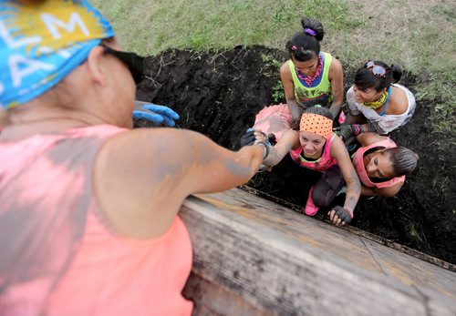 A team helping one member up the Wall of Shame during the Dirty Donkey Run, a 5km run through a muddy obstacle course, at Springhill, Saturday, August 17, 2013. (TREVOR HAGAN/WINNIPEG FREE PRESS)