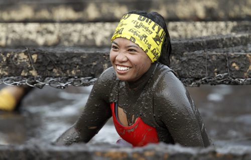 Reyna Domingo emerges from a muddy pit as she nears the finish line of the Dirty Donkey Run, a 5km run through a muddy obstacle course, at Springhill, Saturday, August 17, 2013. (TREVOR HAGAN/WINNIPEG FREE PRESS)