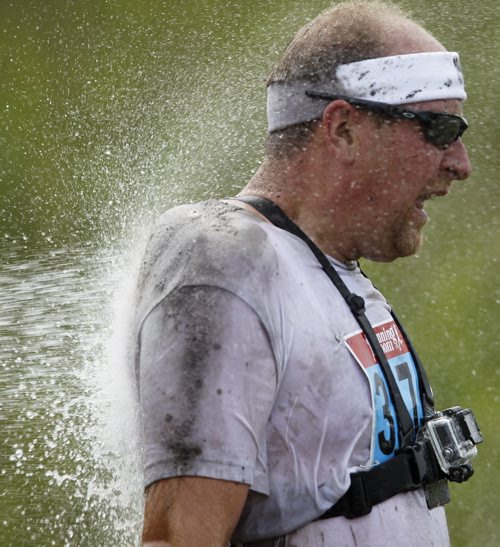 A participant is hosed off after completing the Dirty Donkey Run, a 5km run through a muddy obstacle course, at Springhill, Saturday, August 17, 2013. (TREVOR HAGAN/WINNIPEG FREE PRESS)