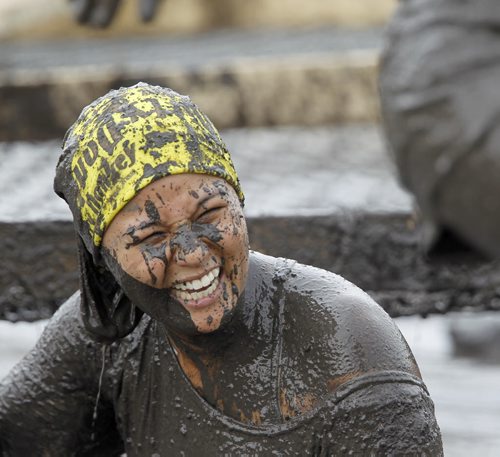 Lillian Mendoza emerges from a muddy pool near the finish line of the Dirty Donkey Run, a 5km run through a muddy obstacle course, at Springhill, Saturday, August 17, 2013. (TREVOR HAGAN/WINNIPEG FREE PRESS)