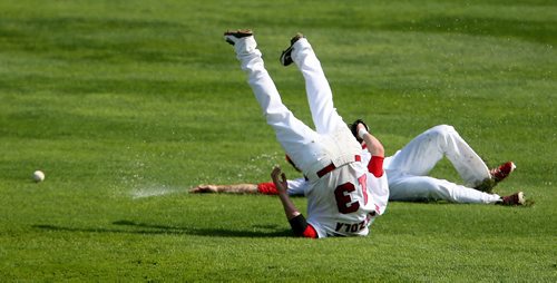 Winnipeg Goldeyes' Josh Mazzola slips while back peddling and ends up on his head while outfielder Tyler Graham also slips behind him while both were trying to catch a fly ball early in the teams game against the Kansas City T-Bones, Sunday, August 18, 2013. (TREVOR HAGAN/WINNIPEG FREE PRESS)