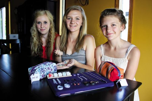 Canstar Community News AUGUST 15, 2013 -- Lauren Wittman (centre) her cousin Zoee (left) and sister Jenna show off some of the jewelry theyÄôve made reusing old film negatives, plastic milk jugs, scraps of fabric and Scrabble game tiles they say would otherwise end up in the garbage. (MATT PREPROST / CANSTAR COMMUNITY NEWS)