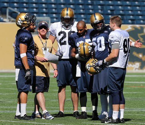 Blue Bomber coach Tim Burke talks with players  during practice including new DB , Bo Smith #25 recently from Hamilton .(4th from the left)  KEN GIGLIOTTI / Aug 21 2013 / WINNIPEG FREE PRESS