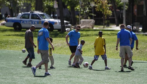 The Winnipeg Police Cadets play a round of soccer with neighbourhood children in Winnipeg's Central Park during the third annual Kickin' It With Cadets event on Wednesday, August 21, 2013. (JESSICA BURTNICK/WINNIPEG FREE PRESS)
