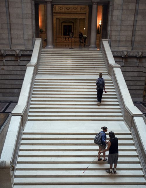Kiley Smith helps Patrick Norman (right) navigate the main stairwell inside the Manitoba Legislature while friend Josh Forfar, who has visited before, leads the way. Wednesday, August 21, 2013. (JESSICA BURTNICK/WINNIPEG FREE PRESS)