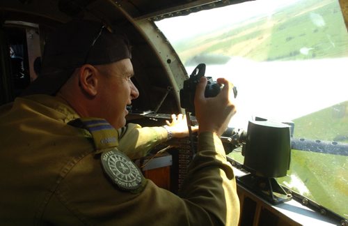 Brandon Sun Pilot Mike Houle of the 3CFFTS squadron in Portage la Prairie, shoots a video through the waist-gunner windows shortly after take-off on Wednesday morning in the Sentimental Journey B-17. (Bruce Bumstead/Brandon Sun)