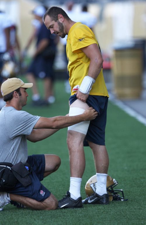 Winnipeg Blue Bombers quarterback Buck Pierce gets a tensor bandage applied by head athletic therapist Alain Couture on the field during practice Thursday at Investors Group Field -See story- August 22, 2013   (JOE BRYKSA / WINNIPEG FREE PRESS)