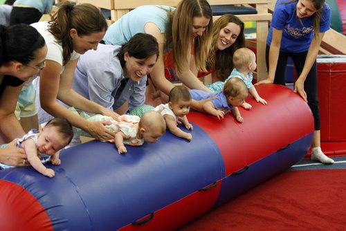 mother roll their infant children durin Little Bundles exercis class  -Childhood Obesity Äì The My Gym location specializes in fitness for infant and young children  - storey by Randy Turner fr 49.8  KEN GIGLIOTTI / Aug 22 2013 / WINNIPEG FREE PRESS