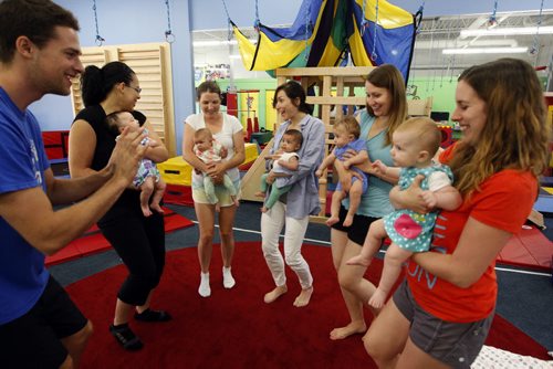 staff member Robin Brister lead mothers with their infant children in a dance during  Little Bundles time- Childhood Obesity Äì The My Gym location specializes in fitness for infant and young children  - storey by Randy Turner fr 49.8  KEN GIGLIOTTI / Aug 22 2013 / WINNIPEG FREE PRESS
