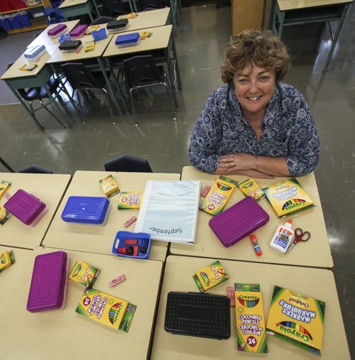 Holly Mackie, principal at Carpathia Elementary School, sits in a classroom with enough school supplies strewn around to last the 2013-2014 academic year for an entire classroom of students. Many local schools, such as Carpathia Elementary, help keep the cost of supplies low because teachers do much of the purchasing for the parents. Thursday, August 22, 2013. (MONEY MATTERS) (JESSICA BURTNICK/WINNIPEG FREE PRESS)