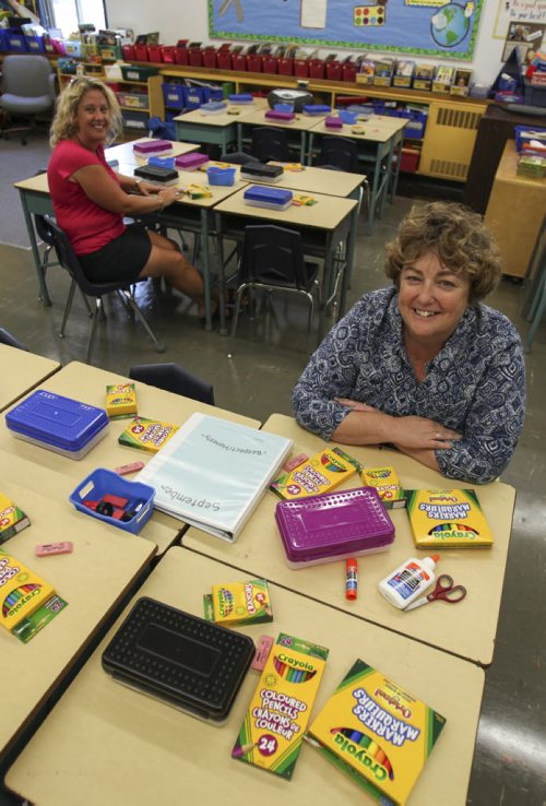 Holly Mackie (right), principal at Carpathia Elementary, and teacher Andrea Thio sit in a classroom with enough school supplies strewn around to last the 2013-2014 academic year for an entire classroom of students. Many local schools, such as Carpathia Elementary, help keep the cost of supplies low because teachers do much of the purchasing for the parents. Thursday, August 22, 2013. (MONEY MATTERS) (JESSICA BURTNICK/WINNIPEG FREE PRESS)