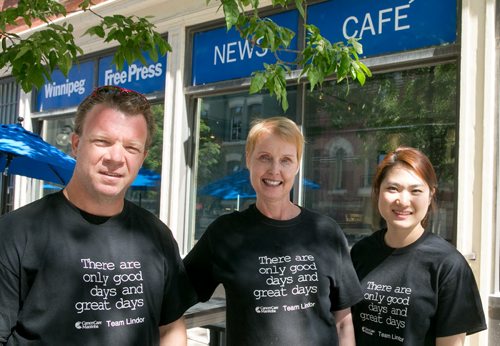 Free Press columnist Lindor Reynolds (centre) is joined by reporter Geoff Kirbyson and Free Press News Caf¾© manager Eunice Kim. Reynolds, who has been diagnosed with brain cancer, is selling Team Lindor t-shirts to fundraise for CancerCare Manitoba.  130822 - Thursday, August 22, 2013 - (Melissa Tait / Winnipeg Free Press)