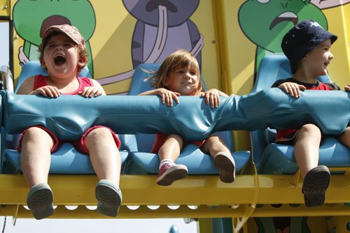 (Left to right) Cousins Livian Zacharias, 6, Paige Barkley, 2, and Connor Zacharias, 5, are all smiles on a midway ride. Established in 1967, the Morden Corn and Apple Festival is the town's chief attraction, and is always held in the fourth week of August. Friday, August 23, 2013. (JESSICA BURTNICK/WINNIPEG FREE PRESS)