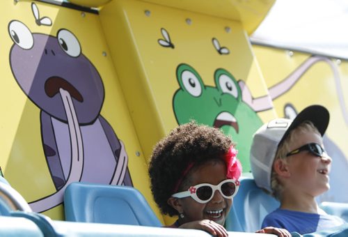 Four-year-old Nyah Megarrell (left), 4, of Morden, is looking pretty cool and collected on a midway ride. Established in 1967, the Morden Corn and Apple Festival is the town's chief attraction, and is always held in the fourth week of August. Friday, August 23, 2013. (JESSICA BURTNICK/WINNIPEG FREE PRESS)