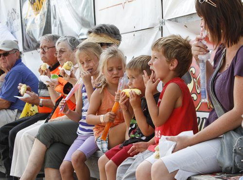 Four-year-old Trey Waite of Morden chows down on corn surrounded by others doing more of the same. Established in 1967, the Morden Corn and Apple Festival is the town's chief attraction, and is always held in the fourth week of August. Friday, August 23, 2013. (JESSICA BURTNICK/WINNIPEG FREE PRESS)