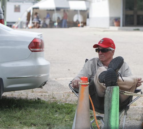 Pastor Mal Wagner of the Morden Church of God takes it easy while manning the parking lot for shuttle buses and tourist drop-offs. Established in 1967, the Morden Corn and Apple Festival is the town's chief attraction, and is always held in the fourth week of August. Friday, August 23, 2013. (JESSICA BURTNICK/WINNIPEG FREE PRESS)