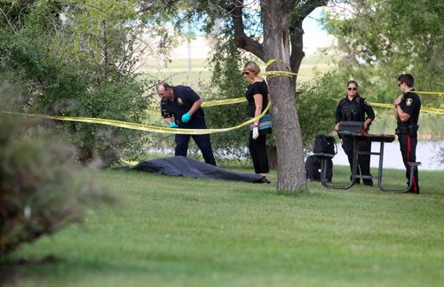 Police Officers inspect a body found in Woodsworth Park Saturday morning.   August  24,, 2013 Ruth Bonneville Winnipeg Free Press