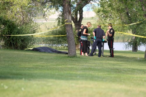 Police Officers inspect the area around a body found in Woodsworth Park Saturday morning.   August  24,, 2013 Ruth Bonneville Winnipeg Free Press