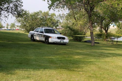 Police Officers guard the area surrounding a body found in Woodsworth Park Saturday morning.   August  24,, 2013 Ruth Bonneville Winnipeg Free Press