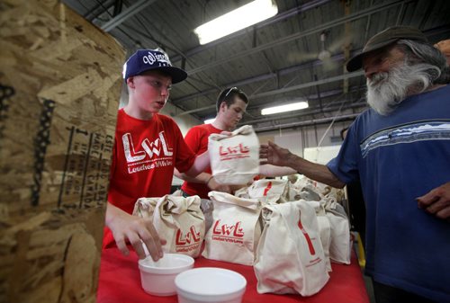 Thirteen year old Nathan Unrau  along with many volunteers hand out hundreds of lunchs to city's less fortunate at Siloam Mission over the lunch hour Saturday. The Winnipeg teen has been making lunches for the homeless since last October when he was inspired by We Day events. See Oliver Sachgau's story.  August  24, 2013 Ruth Bonneville Winnipeg Free Press