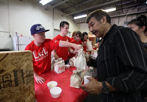 Thirteen year old Nathan Unrau  along with many volunteers hand out hundreds of lunchs to city's less fortunate at Siloam Mission over the lunch hour Saturday. The Winnipeg teen has been making lunches for the homeless since last October when he was inspired by We Day events. See Oliver Sachgau's story.  August  24, 2013 Ruth Bonneville Winnipeg Free Press