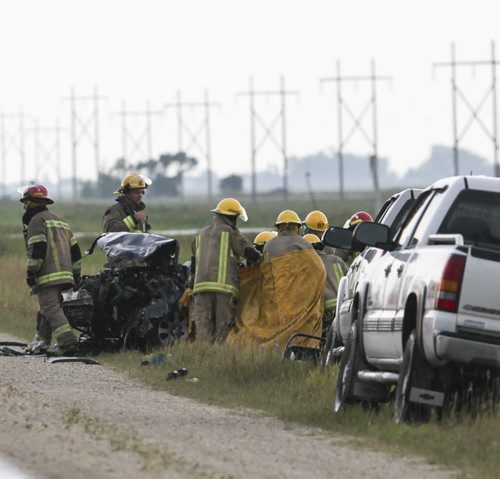 Emergency personnel remove the body of a crash victim from the vehicle. A crash involving two vehicles occurred on Highway 3 about 2-kms West of Brunkild, Man. today around 4 p.m. One infant and one child were among the victims. Two people were dead at the scene, and the others transported to hospital. Saturday, August 24, 2013. (JESSICA BURTNICK/WINNIPEG FREE PRESS)