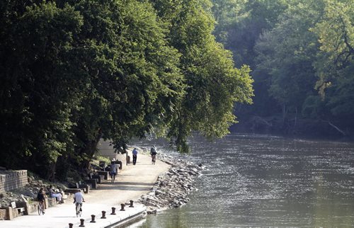 People walking and riding along the river walk that follows the Assiniboine River near the Legislative Building, Sunday, August 25, 2013. (TREVOR HAGAN/WINNIPEG FREE PRESS)