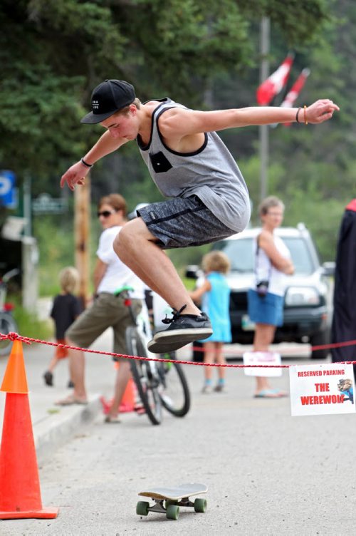 Brandon Sun 24082013 Matthew Genik of Dauphin does a trick called a hippy jump over a rope barricade while skateboarding in Wasagaming on a beautiful Saturday morning. (Tim Smith/Brandon Sun)