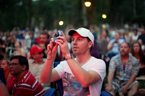 Brandon Sun 24082013 A fan takes a photograph as Glass Tiger performs during a free concert in honour of Riding Mountain National Park's 80th Anniversary on Saturday evening. Fans filled the grass and the beach adjacent to Clear Lake for the concert which also included performer Jess Moskaluke. (Tim Smith/Brandon Sun)