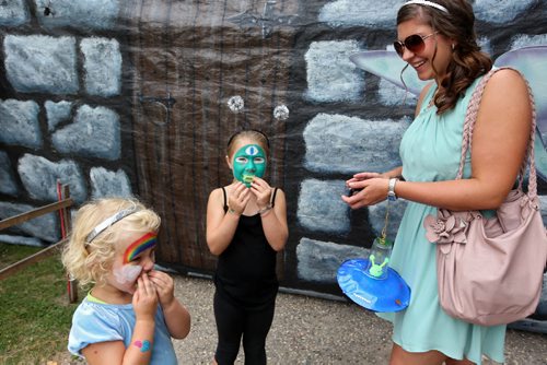 Brandon Sun 24082013 Sisters Cameron and Emyrsen Carefoot check out the fangs they were given by Frankensteins Monster while visiting Hotel Transylvania at the Friends of Riding Mountain National Park building with their babysitter Meaghan Halabisky during Boo in the Park in Wasagaming on Saturday. (Tim Smith/Brandon Sun)