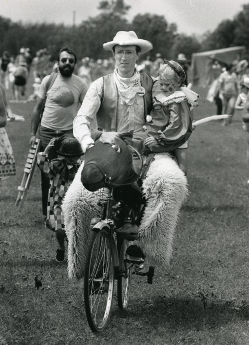 40 years of Folk Fest -- Al Simmons, in usual sedate attire, gives a child a lift on his horse bike. July 17, 1984. (KEN GIGLIOTTI/WINNIPEG FREE PRESS ARCHIVES) winnipeg folk festival. fparchives