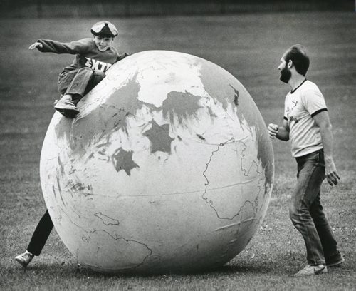 40 years of Folk Fest -- Hoel Bailey, 10, finds he has to fight the forces of gravity to complete his world tour of continents marked on the earth ball at te Winnipeg Folk Festival. John Radcliffe monitors the youg traveller's progress. July 12, 1986. (PHIL HOSSACK/WINNIPEG FREE PRESS ARCHIVES) winnipeg folk festival. fparchives