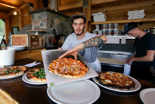 Brandon Sun Sous Chef Zachary Bertram takes pizzas out of the wood oven at the Foxtail Cafe on Saturday evening just to the south of Riding Mountain National Park on Highway 10. (Tim Smith/Brandon Sun)