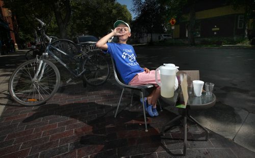 Ten year old Roman Huculak seems to be "his own best customer" while maning his lemonade stand at the corner of Evanson and Westminister Wednesday afternoon. He reported business was brisk with temperatures  hovering in the mid 30C's with a high humidex. STAND UP August 28, 2013 - (Phil Hossack / Winnipeg Free Press)