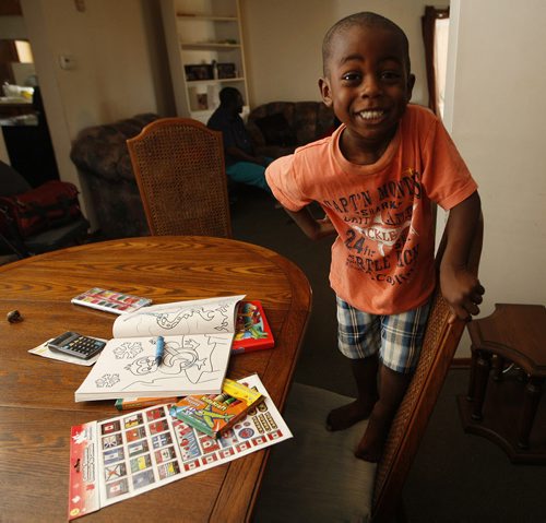 grandson Ben Mulimbwa age 4 is ready  for  preschool- Back to School feature  , new Canadians  going to schol for the first time in Canada Äì in other  Mulimbwa family  photo - for  LtoR Äì daughter Alliance age 15 , Francine 22  ,Glodi 13, sitting grandson Ben Mulimbwa age 4 (seated colouring will be going to preschool) ,Sylvia  age 25 , father Bahati and mother Esperance Safari Äì Oliver Sachgau story- KEN GIGLIOTTI / Aug 29 2013 / WINNIPEG FREE PRESS