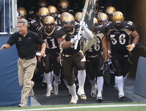 Bison coach Brian Dobie, left, leads his team  onto the field at  Investors Group Field during Manitoba Bisons home against the University of Alberta Golden Bears Friday night  -See story- August 30, 2013   (JOE BRYKSA / WINNIPEG FREE PRESS)