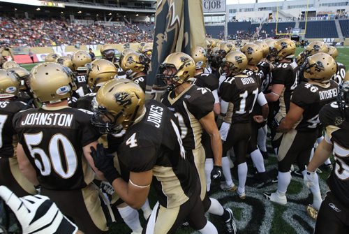 University Of Manitoba Bison Players gather at centre field at the beginning of their game against the University of Alberta Golden Bears in their new stadium at Investors Group Field Friday night  -See story- August 30, 2013   (JOE BRYKSA / WINNIPEG FREE PRESS)