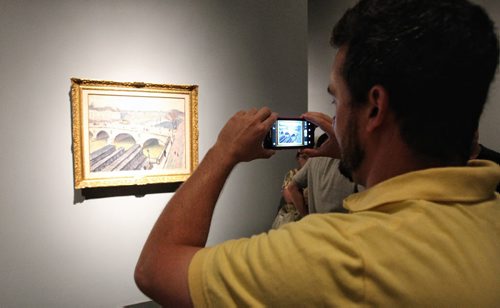Chris Otis snaps a photo of an Albert Marquet painting as crowds filled up the rooms of the Winnipeg Art Gallery Monday on the final day of the 100 Masters Exhibition. When doors close at the end of the day the exhibit is expected to have drawn over 60,000 visitors, the WAG's largest in its 100 years.  130902 - September 02, 2013 Mike Deal / Winnipeg Free Press