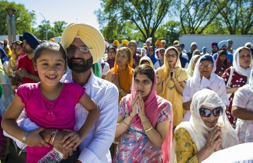 130901 Winnipeg - DAVID LIPNOWSKI / WINNIPEG FREE PRESS (September 01, 2013) Jaswant Gill holds his daughter Amanvir  Gill (age 6) during prayer at the Nagar Kirtan parade Sunday afternoon. Thousands of Sikh people participated in the annual Nagar Kirtan celebration which included a religious parade that finished at Memorial Park.