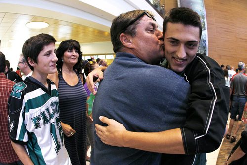 September 2, 2013 - 130902  -  Bryce Leblanc of Winnipeg's Greendell Falcons Euroteam who beat the Bristol Pride in The Gathering Bowl in Dublin, Ireland gets a kiss from his dad Tighe as his mom Lorrie and brother Reid look on as the team arrives at Winnipeg's airport Monday September 2, 2013. Leblanc was also the tournament's most valuable player. John Woods / Winnipeg Free Press