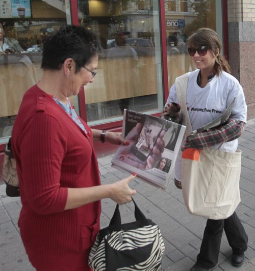 Jamie Ashton (right) handing out free Winnipeg Free Press newspapers on Portage Ave. and Carlton St¤on the morning of the launch of the new Blippar App. (Note she is not a free press employee, just hired for the day) Wayne Glowacki / Winnipeg Free Press Sept. 4 2013