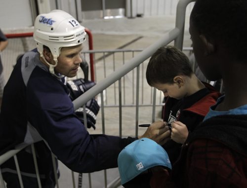 Some Winnipeg Jets players and rookies take part in an informal practice at the MTS Iceplex Wednesday morning. Jets forward #12 Olli Jokinen signs the shirt of five year old Eric Nanka.  Gary Lawless Story. Wayne Glowacki / Winnipeg Free Press Sept. 4 2013