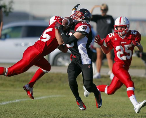 Winnipeg Highschool football game between the Sisler Spartins and Kelvin Clippers. Spartins #28 Ethan Paul gets tackled by some Clippers. BORIS MINKEVICH / WINNIPEG FREE PRESS. August 4, 2013