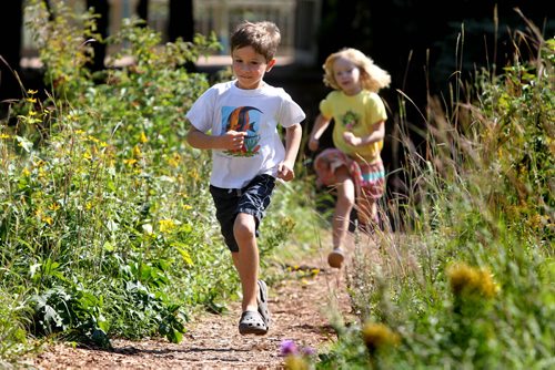 Seven year old Dru Culleton races through the prairie garden path with his sister Mae - 5yrs while visiting the Forks with their mom Thursday afternoon on their last day off of school. The young students who are in the St. Boniface school division start their first day of classes tomorrow morning  Standup feature photo. Sept 05,, 2013 Ruth Bonneville Winnipeg Free Press