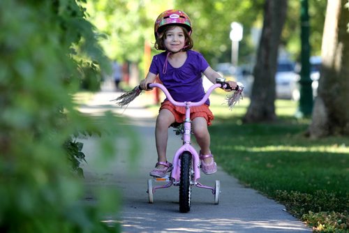 Four year old Sylvia Press enjoys a morning cycle with her mom and dog along Lanark Saturday. Standup photo Sept 07,, 2013 Ruth Bonneville Winnipeg Free Press