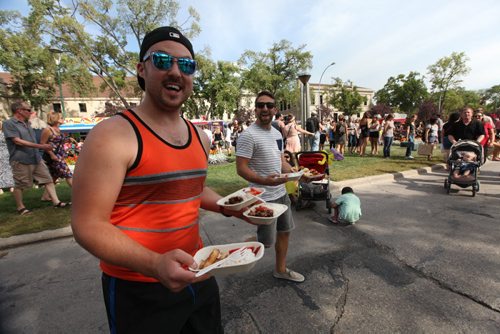 Stephen Pawulski -left and Mike Del Buono are just a few of the hundreds of people who didn't mind waiting in long lines  to sample food from various specialty food trucks taking part in the Food Truck Wars at Manyfest on Broadway over the weekend.  See Adam Wazny's story.  Sept 07,, 2013 Ruth Bonneville Winnipeg Free Press