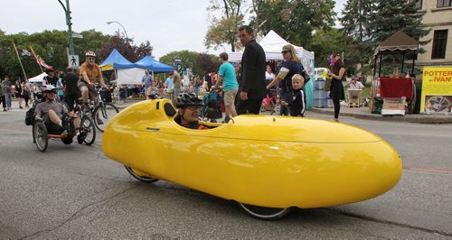 Kevin Champaign turns heads as he rides his Yellow Velomobile along Broadway during Cyclovia Sunday afternoon.  130908 September 08, 2013 Mike Deal / Winnipeg Free Press