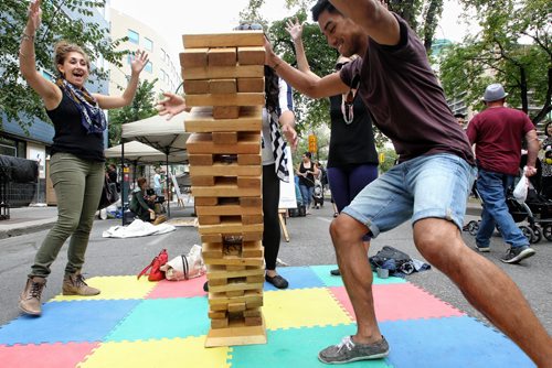 Bailey Gilies (left) and Philip Rosario (right) react as their Giant Jenga tower falls during Cyclovia on Broadway Sunday afternoon.  130908 - September 08, 2013 Mike Deal / Winnipeg Free Press