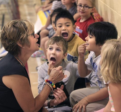 Nancy Allan, Minister of Education is shown missing teeth in grade one students from left, Hunter Stephenson, Kiel Tanalas and Chaz Nelson at  École Assiniboine School Tuesday prior to the announcement the province will continue to reduce kindergarten to grade 3 class sizes.     Nick Martin story Wayne Glowacki / WinnipegFree Press Sept. 10  2013