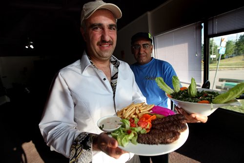 Pyramid Land - RESTAURANT REVIEW - Nezar Abdulahad (left) holds a Kabab Platter, while partner Maged Bilates poses with the Tabooli Salad  ( Spelling is from the restraunt menu )September 10, 2013 - (Phil Hossack / Winnipeg Free Press)